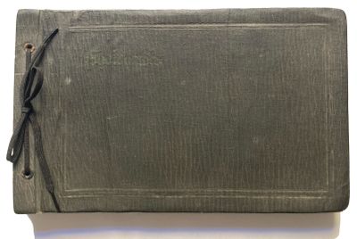 un vieux livre à la couverture en cuir posé sur une table blanche