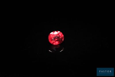 gros plan d'un diamant rouge sur une surface noire