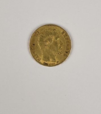 gros plan d'une pièce d'or sur une surface blanche