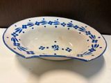 blue and white bowl on a white table with a brown background