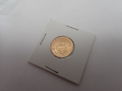 gros plan d'une pièce d'or sur une surface blanche