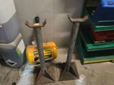 two tools that are sitting on the floor next to a trash can