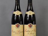 two bottles of wine sitting on top of a table next to each other