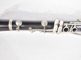 a black and silver clarinet sitting on a white surface