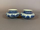 two blue and white vases sitting on top of a table