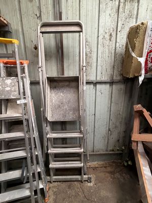 several ladders are stacked next to each other in a room