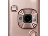 an instax mini camera with a pink cover