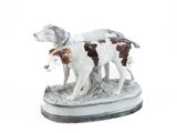 une figurine représentant deux chiens debout sur un socle