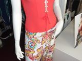 a mannequin wearing a red top and colorful pants