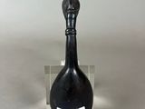 a small black bottle with a label on it