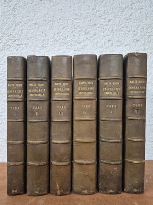 five old books sitting on top of a wooden table