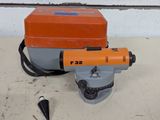 une machine orange et grise posée sur un plancher en bois