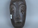 une image représentant un masque en bois sur fond gris