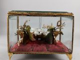 a glass display case with animals in it on a red cushion