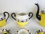 cinq tasses et une théière posées sur une table