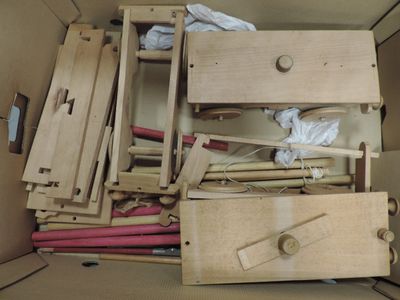 a cardboard box filled with assorted wooden furniture