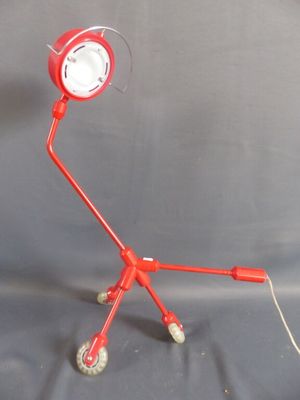 une lampe rouge posée sur un trépied
