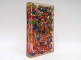 brightly colored lollipops in a clear box on a white background