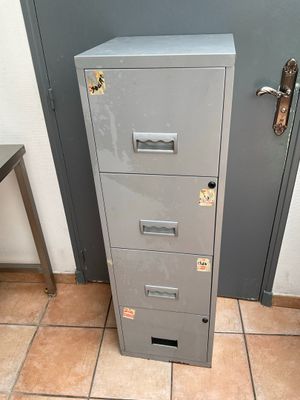 a metal filing cabinet in the corner of a room