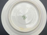 a white plate with a green leaf on it