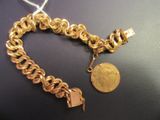 une photo d'un bracelet en chaîne dorée orné d'une pièce de monnaie