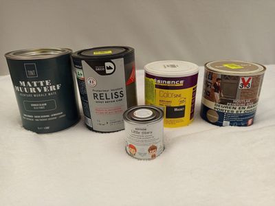 several cans of paint are sitting on a white surface