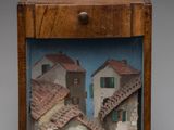 an image of a wooden box with a picture of a village inside of it