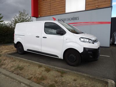 la camionnette blanche est garée devant un bâtiment dans un parking