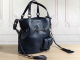 a black handbag sitting on top of a wooden table next to a wall
