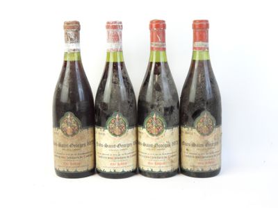 quatre bouteilles de vin sont alignées sur une surface blanche