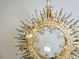 a gold sunburst hanging from the ceiling in a room