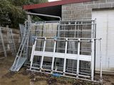 a pile of metal ladders outside of a building