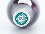 a close up of a bottle of wine on a white surface