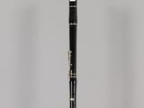 a close up of a black and white clarinet on a clear stand