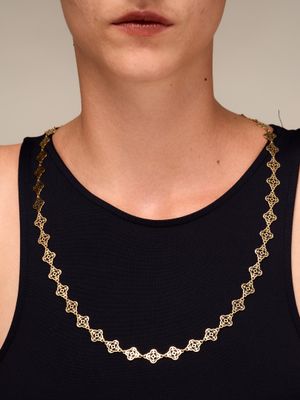 a woman wearing a black tank top and a gold chain necklace