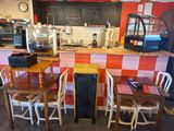 des tables et des chaises dans un restaurant avec un tableau noir accroché au mur