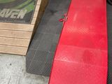 une rampe rouge située à côté d'une caisse sur laquelle se trouve un pneu