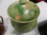 a green pot with a lid sitting on a table