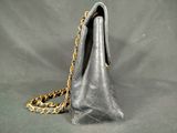 a close up of a purse with a chain on a gray background