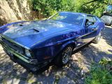 une photo d'une « muscle car » bleue garée sur le bord de la route