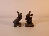 deux figurines de lapins assis l'une sur l'autre