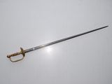 an old sword on a white surface with a gold handle