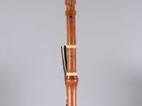 a close up of a wooden bassoon on a clear acrylic stand