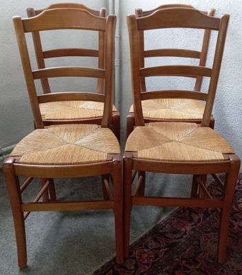 deux chaises en bois placées l'une à côté de l'autre sur un tapis