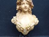 statue of a woman with a flower in her hair on a black surface