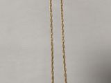 un collier à chaîne en or orné d'une petite étiquette blanche