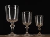 three empty wine glasses sitting on top of a wooden table