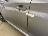 a silver car with a sticker on the door handle