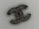 un gros plan d'une broche en noir et blanc arborant le logo Chanel