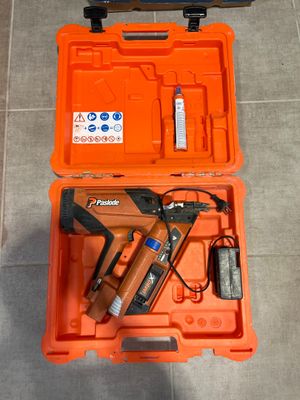 une boîte à outils orange contenant une agrafeuse et un pistolet à clous